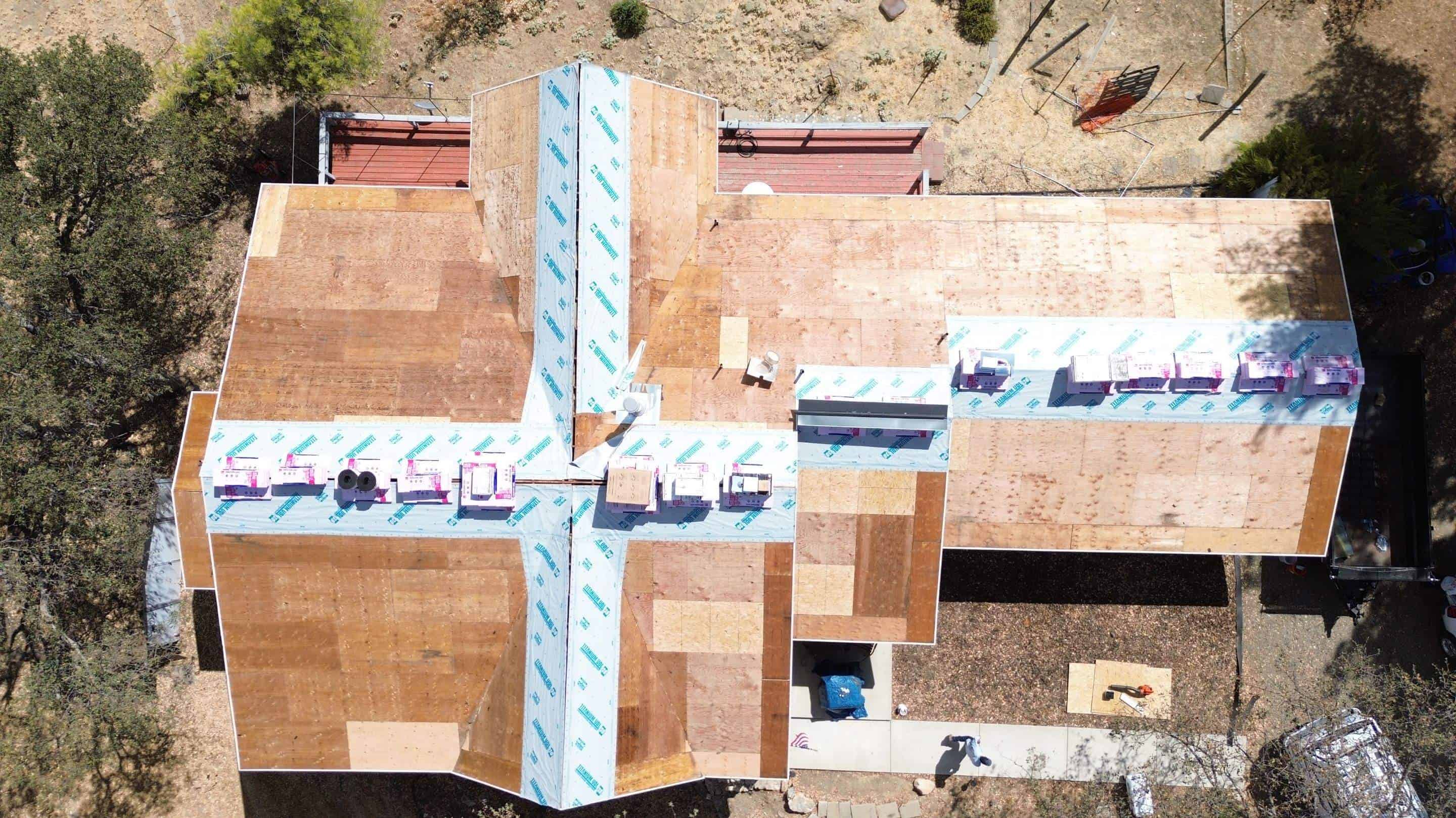 A team of workers replacing worn-out residential roof with new materials.